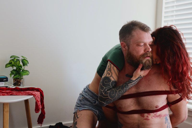A sexy photograph of Cam Damage & Mike Panic. Tagged with: chemistry, intimate, submission, dominance, real couple, bondage & rope.